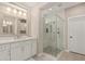 Bright bathroom with glass enclosed shower, white cabinets, and stone floors at 36053 N Stoneware Dr, Queen Creek, AZ 85140