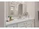 Bathroom with white cabinets, quartz countertop, elegant mirror and fixtures at 36053 N Stoneware Dr, Queen Creek, AZ 85140