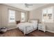 Cozy bedroom with bright windows and window seat, wood floors, and ceiling fan at 36053 N Stoneware Dr, Queen Creek, AZ 85140