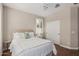Bedroom with bright windows and white sliding door closet, wood floors, and ceiling fan at 36053 N Stoneware Dr, Queen Creek, AZ 85140
