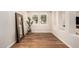 Bright flex room features hardwood floors, modern mirror, and large windows, creating a versatile space at 36053 N Stoneware Dr, Queen Creek, AZ 85140