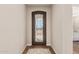Foyer featuring an ornate wrought iron front door, hardwood flooring, and light neutral walls at 36053 N Stoneware Dr, Queen Creek, AZ 85140