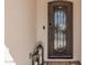 Close up of front door featuring an ornate iron door with a glass insert and decorative lanterns at 36053 N Stoneware Dr, Queen Creek, AZ 85140
