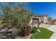 Beautiful landscaping frames this home exterior, featuring lush plants and stone accents enhancing the curb appeal at 36053 N Stoneware Dr, Queen Creek, AZ 85140