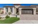Charming home featuring a brown garage door, landscaped front yard, and inviting entryway with decorative details at 36053 N Stoneware Dr, Queen Creek, AZ 85140