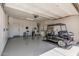 Bright and organized garage with epoxy floors and a golf cart parked inside at 36053 N Stoneware Dr, Queen Creek, AZ 85140