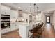 Gourmet kitchen boasts white cabinets, granite countertops, stainless steel appliances, and modern fixtures at 36053 N Stoneware Dr, Queen Creek, AZ 85140