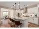 Open-concept gourmet kitchen with white cabinetry, granite countertops, stainless appliances and seating at the island at 36053 N Stoneware Dr, Queen Creek, AZ 85140