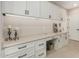 Bright laundry room with white cabinets, white countertops, and a desk space at 36053 N Stoneware Dr, Queen Creek, AZ 85140