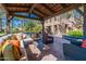 Comfortable outdoor living space with a stone fireplace, plush seating, and a decorative tiled wall, perfect for relaxation at 36053 N Stoneware Dr, Queen Creek, AZ 85140