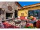 Charming outdoor patio with a stone fireplace, comfortable seating, and lush greenery, creating a relaxing retreat at 36053 N Stoneware Dr, Queen Creek, AZ 85140
