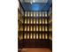 A custom wine cellar that features wooden cabinets with backlighting to provide an elegant ambiance at 36053 N Stoneware Dr, Queen Creek, AZ 85140