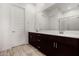 Modern bathroom featuring dual sinks, sleek cabinetry, and a large mirror reflecting a glass-enclosed shower at 3842 E Bartlett Way, Chandler, AZ 85249