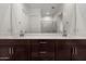 Bathroom featuring dual sinks, dark cabinetry, and a large vanity mirror at 3842 E Bartlett Way, Chandler, AZ 85249