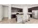 Modern kitchen featuring stainless steel appliances, a kitchen island with seating, and dark wood cabinetry at 3842 E Bartlett Way, Chandler, AZ 85249