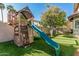Backyard featuring play structure with slide, climbing wall, swing, and low maintenance synthetic grass at 3917 E Des Moines St, Mesa, AZ 85205