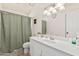 Bright bathroom featuring a single sink vanity and a shower with a green curtain at 3917 E Des Moines St, Mesa, AZ 85205