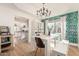 Bright dining room with stylish wallpaper, hardwood floors, and modern chandelier at 3917 E Des Moines St, Mesa, AZ 85205