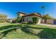 Side view of a well-kept home with green lawn, landscaped shrubs, and a private driveway at 3917 E Des Moines St, Mesa, AZ 85205