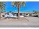 Charming single-story home featuring a white exterior, palm trees, and a covered carport at 4128 W Las Palmaritas Dr, Phoenix, AZ 85051