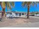 Charming single-story home featuring a white exterior, palm trees, and a covered carport at 4128 W Las Palmaritas Dr, Phoenix, AZ 85051
