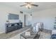 Cozy living room with a modern entertainment center, ceiling fan, and neutral-toned decor at 4128 W Las Palmaritas Dr, Phoenix, AZ 85051