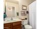 Well-lit bathroom with a decorative mirror and essential amenities for a functional and stylish space at 42568 W Bunker Dr, Maricopa, AZ 85138