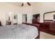This bedroom showcases a ceiling fan, a full dresser set, and a connecting ensuite bathroom at 42568 W Bunker Dr, Maricopa, AZ 85138