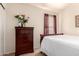 This bedroom shows neutral walls, a traditional dresser, and an inviting, cozy aesthetic at 42568 W Bunker Dr, Maricopa, AZ 85138