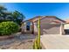 Charming single-story home with a two-car garage, desert landscaping, and a sunny blue sky at 42568 W Bunker Dr, Maricopa, AZ 85138