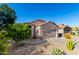 Single-story home showcasing desert landscaping, blue sky, and a well-maintained front yard at 42568 W Bunker Dr, Maricopa, AZ 85138
