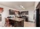 Well-equipped kitchen with dark wood cabinets, stainless steel appliances, and a breakfast bar at 42568 W Bunker Dr, Maricopa, AZ 85138