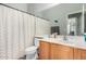 Bathroom with wood cabinets, a large mirror and a shower and tub with a curtain at 45105 W Gavilan Dr, Maricopa, AZ 85139