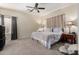 Neutral bedroom with a ceiling fan, carpet and a large bed with two side tables with lamps at 45105 W Gavilan Dr, Maricopa, AZ 85139