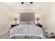 Neutral primary bedroom with two side tables, lamps, carpet and a decorative pillow at 45105 W Gavilan Dr, Maricopa, AZ 85139