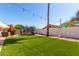 Green backyard featuring well-kept artificial turf, shade trees, and a trampoline, perfect for outdoor activities at 4779 W Tulsa St, Chandler, AZ 85226