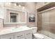 Stylish bathroom with a vanity, marble countertop, framed mirror, and tiled shower behind glass doors at 4779 W Tulsa St, Chandler, AZ 85226