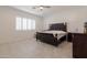 Spacious bedroom with large window, plantation shutters, and a tufted headboard at 5226 W Thresher Way, Laveen, AZ 85339