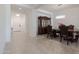 Open-concept dining area with tiled floors, classic furniture, and view to the front door at 5226 W Thresher Way, Laveen, AZ 85339