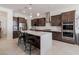 Spacious kitchen features a large island, stainless steel appliances, and dark wood cabinetry at 5226 W Thresher Way, Laveen, AZ 85339