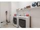 Bright laundry room features updated washer and dryer, shelving, and hard surface floors at 5226 W Thresher Way, Laveen, AZ 85339