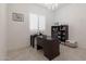 Home office with a dark wood desk, built-in shelves, and white plantation shutters at 5226 W Thresher Way, Laveen, AZ 85339