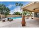Outdoor living at its finest with a covered patio, outdoor kitchen, inviting pool, and lush landscaping at 53 W Pecan Pl, Tempe, AZ 85284