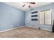 Comfortable bedroom with a ceiling fan, dark shelving, and a window for natural light at 53 W Pecan Pl, Tempe, AZ 85284