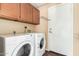 Practical laundry room with side-by-side washer and dryer, with overhead storage cabinets and convenient access to the outside at 53 W Pecan Pl, Tempe, AZ 85284