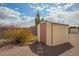 Backyard shed with stone pathway amidst desert landscaping and a giant cactus at 5323 E Dodge St, Mesa, AZ 85205