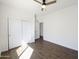 This bedroom has wood-look tile flooring, white walls, ceiling fan, and a closet with sliding doors at 5719 E Santa Clara Dr, San Tan Valley, AZ 85140