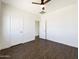This is the bedroom with wood-look tile floors, ceiling fan, white walls and white doors at 5719 E Santa Clara Dr, San Tan Valley, AZ 85140