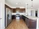 Modern kitchen featuring stainless steel appliances, rich wood cabinets, and a sleek breakfast bar at 5719 E Santa Clara Dr, San Tan Valley, AZ 85140