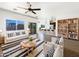 Bright living room boasts a cozy sofa, a ceiling fan, and an open floor plan adjacent to the kitchen at 5719 E Santa Clara Dr, San Tan Valley, AZ 85140
